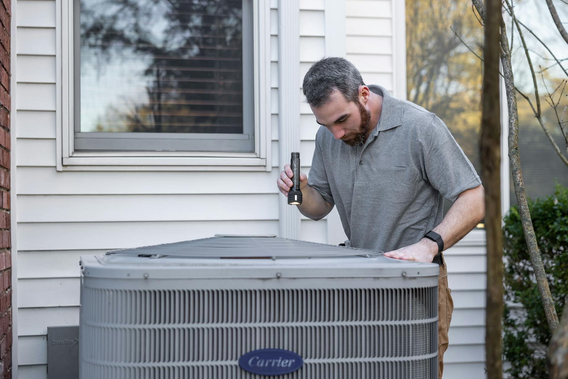 Pool heater repair in Hawaii — technician servicing a heat pump unit on a residential equipment pad