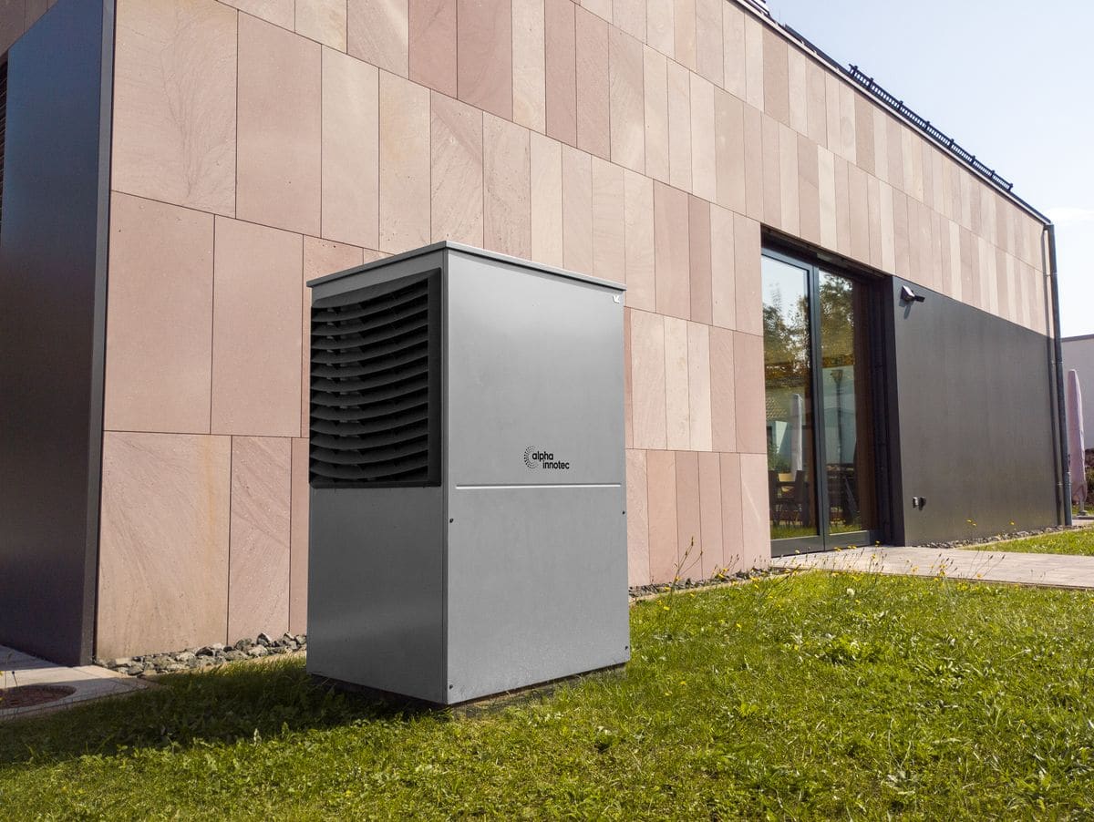 Residential electric pool heat pump unit installed outside a modern home